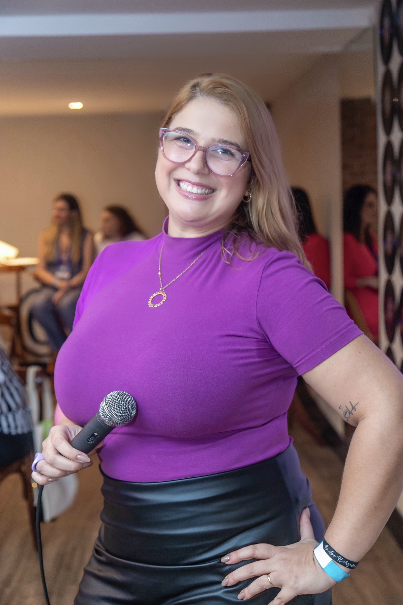 Priscilla Cruz sorrindo com microfone